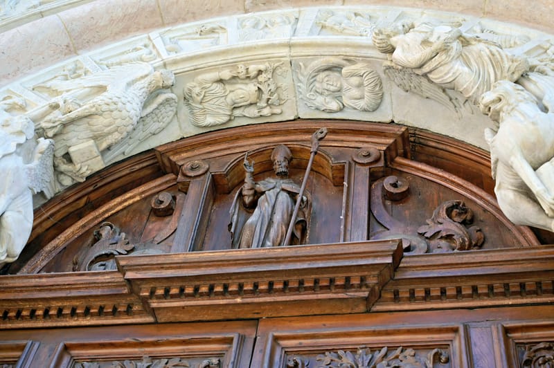 Dettaglio del portale della facciata minore: sovraporta e archivolto con sculture